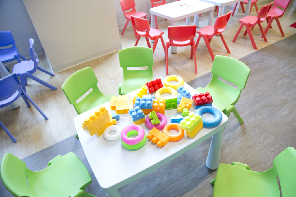 costruzioni colorate sul tavolino dei bambini con intorno le sedioline